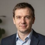 Портрет уверенного российского бизнесмена с дружелюбным взглядом на нейтральном размытом фоне студии
